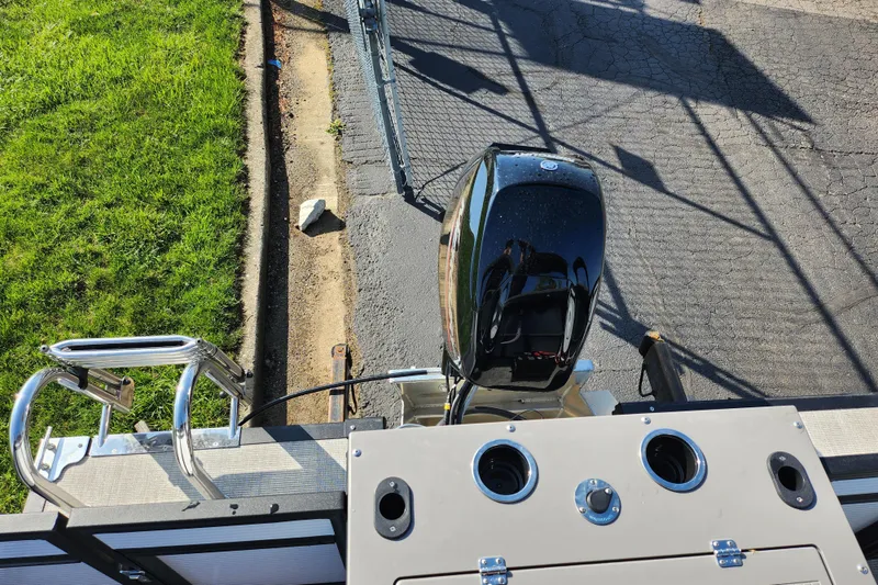 Slide: The Image of 2024 Qwest Angler Qwest XRE boat engine and deck view, parked on pavement. - 18
