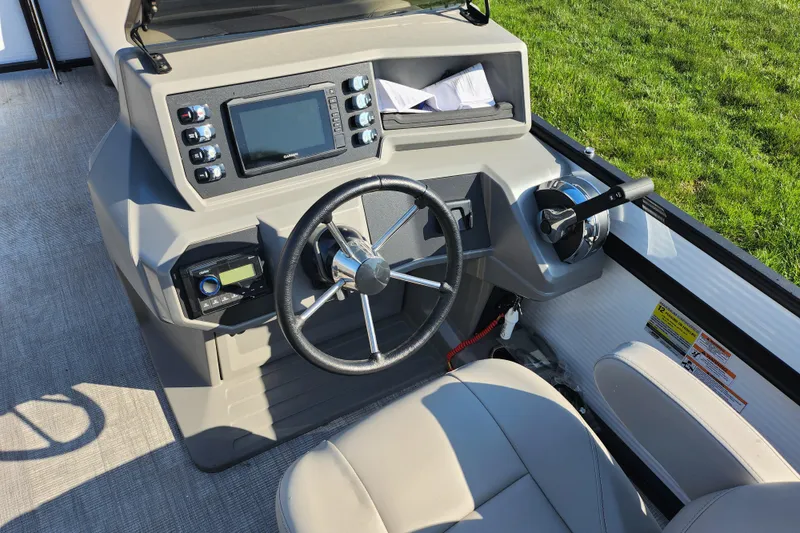 Slide: The Image of 2024 Qwest Angler Qwest XRE boat dashboard with steering wheel and control panel. - 21