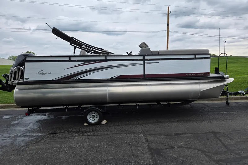 Slide: The Image of 2024 Qwest Angler Qwest XRE pontoon boat on trailer, parked on asphalt. - 4