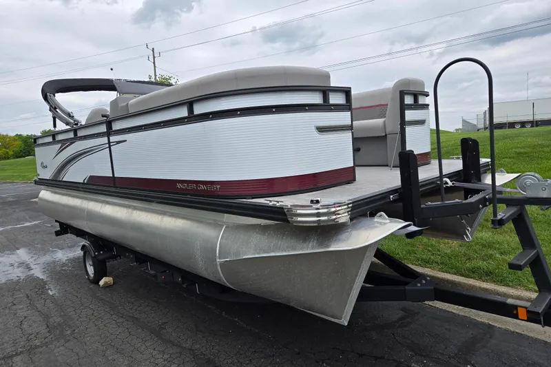 Slide: The Image of 2024 Qwest Angler Qwest XRE pontoon boat on trailer, parked outdoors. - 5