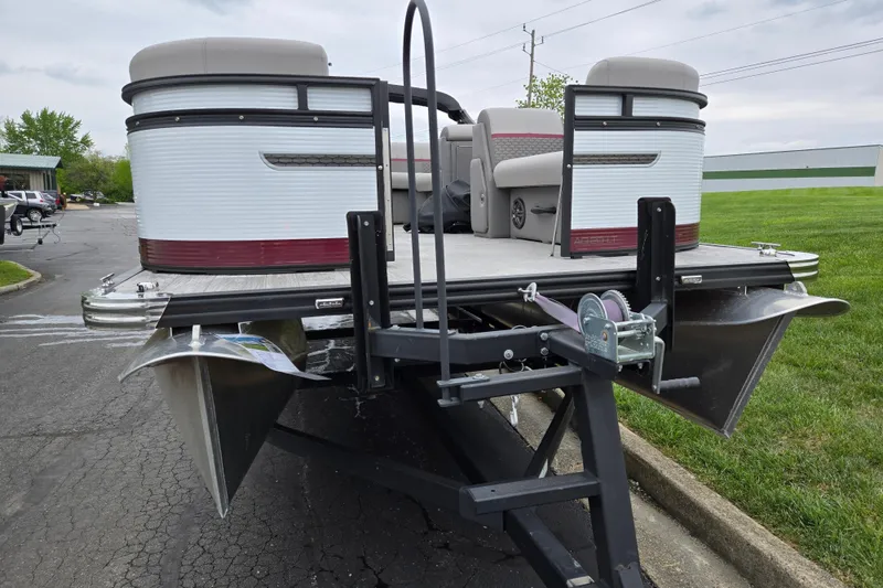 Slide: The Image of 2024 Qwest Angler Qwest XRE pontoon boat on trailer, parked on asphalt near grass. - 6