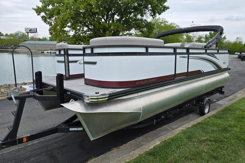 Slide: The Image of 2024 Qwest Angler Qwest XRE pontoon boat on trailer by a lakeside. - 8