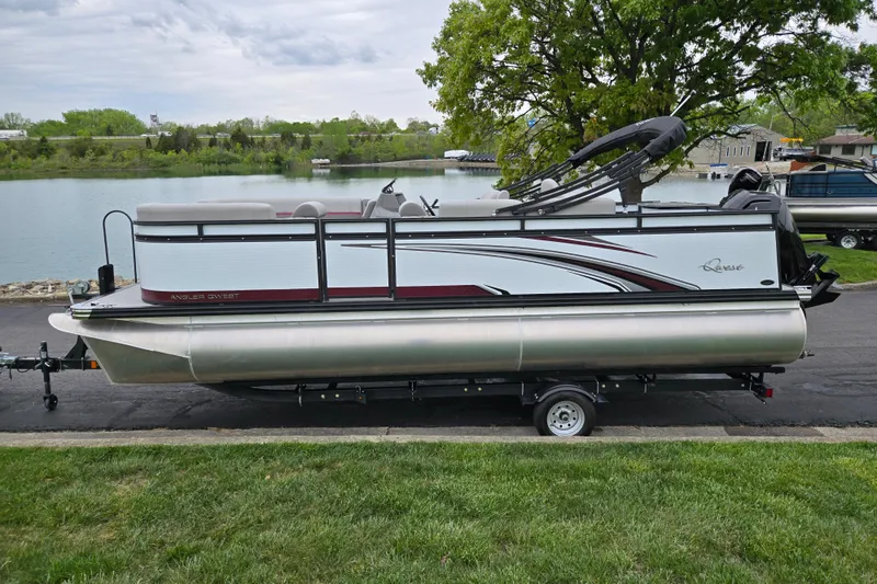Slide: The Image of 2024 Qwest Angler Qwest XRE pontoon boat on trailer by a lake. - 9