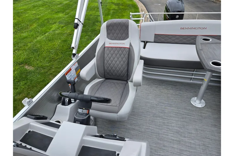 Slide: The Image of 2023 Bennington 22 LSB pontoon boat interior with captain's chair and table. - 13