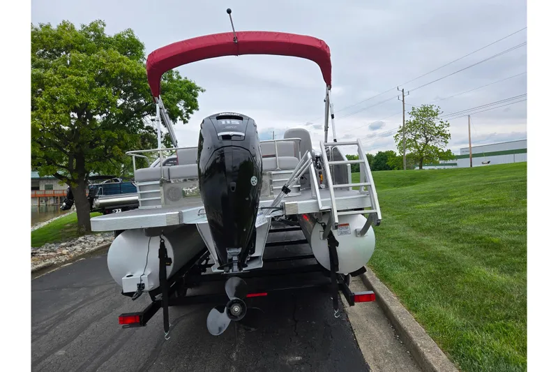 Slide: The Image of 2023 Bennington 22 LSB pontoon boat with red canopy and Mercury outboard motor. - 2