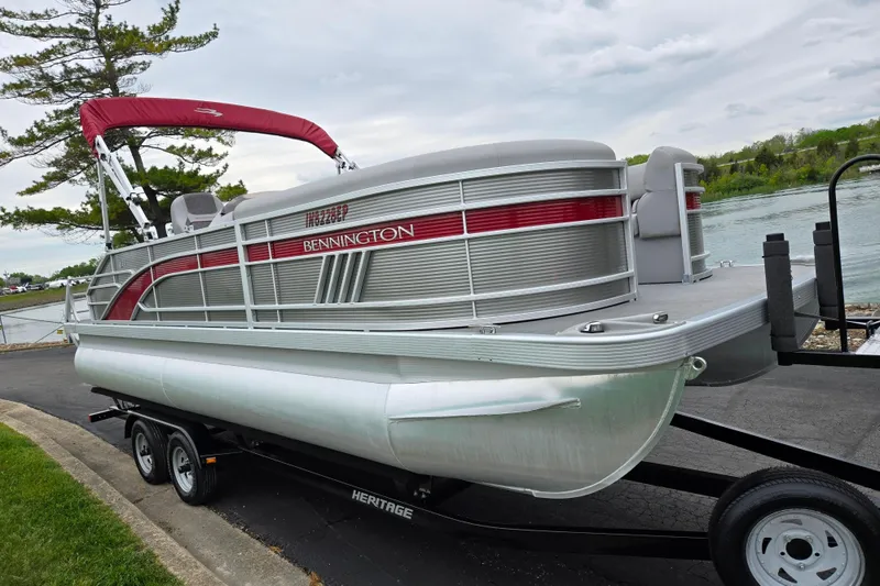 Slide: The Image of 2023 Bennington 22 LSB pontoon boat on trailer by a lakeside. - 9
