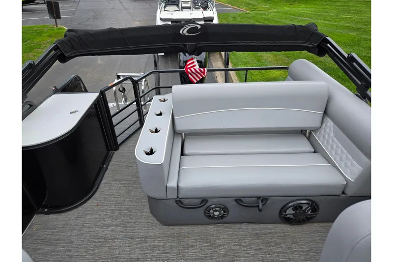 Slide: The Image of 2022 Crest Classic DLX 220 pontoon boat with gray seating and cup holders. - 13