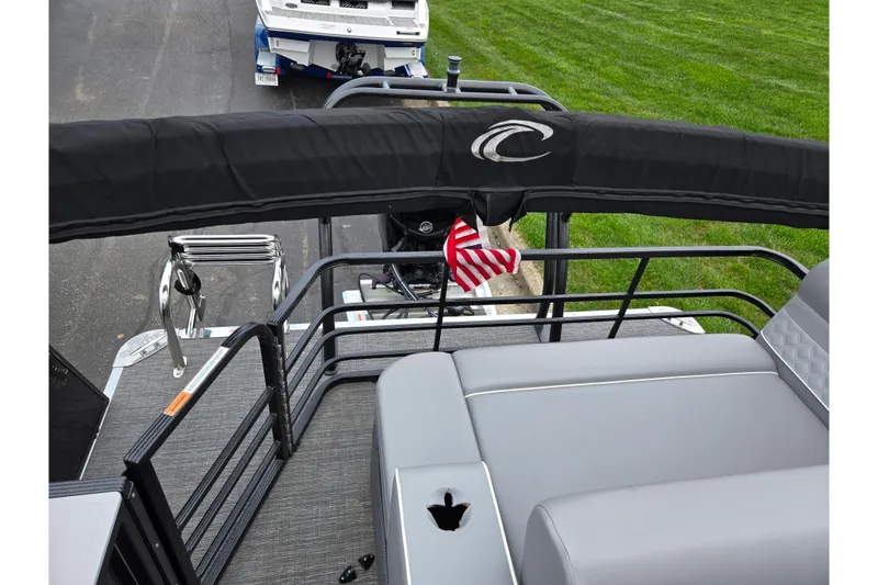 Slide: The Image of 2022 Crest Classic DLX 220 pontoon boat with gray seating and American flag. - 14