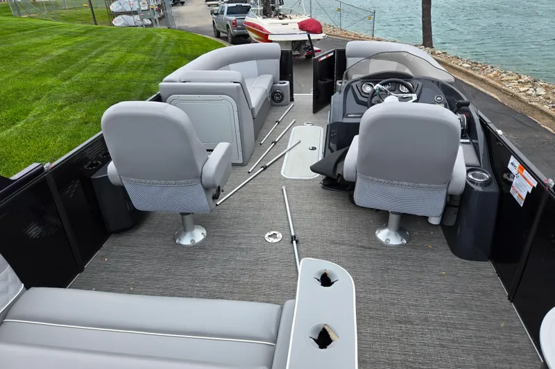 Slide: The Image of 2022 Crest Classic DLX 220 pontoon boat interior with gray seating and steering console. - 16