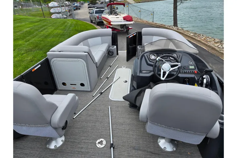Slide: The Image of 2022 Crest Classic DLX 220 pontoon boat interior with gray seating and steering console. - 18
