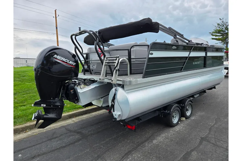 Slide: The Image of 2022 Crest Classic DLX 220 pontoon boat with Mercury outboard motor on trailer. - 2