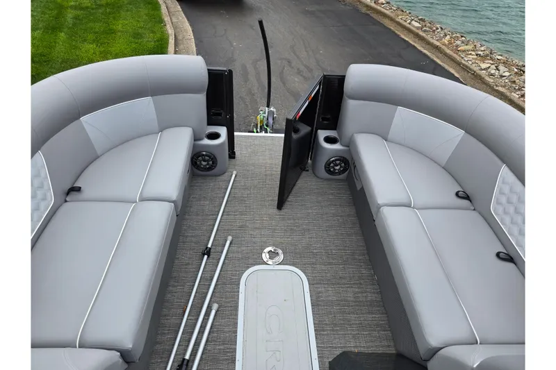 Slide: The Image of 2022 Crest Classic DLX 220 pontoon boat interior with gray seating and speakers. - 23