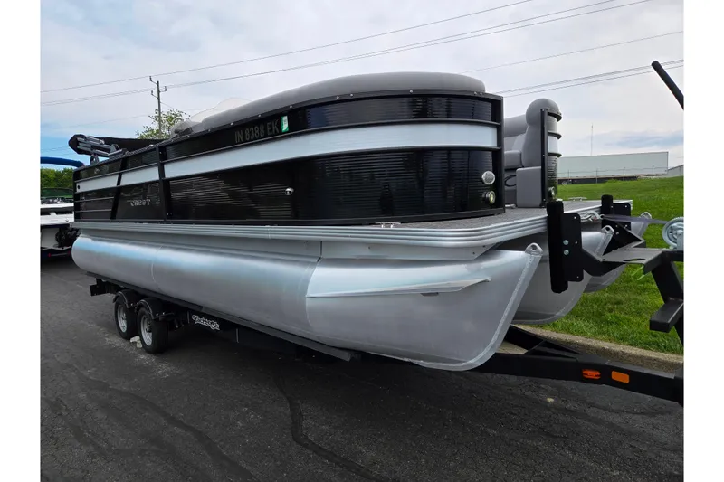 Slide: The Image of 2022 Crest Classic DLX 220 pontoon boat on trailer, parked outdoors. - 4
