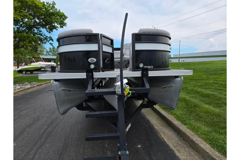 Slide: The Image of 2022 Crest Classic DLX 220 pontoon boat on trailer, parked on paved road. - 5