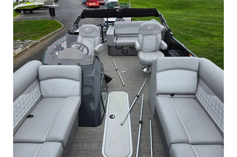 Slide: The Image of 2022 Crest Classic DLX 220 pontoon boat interior with gray seating and steering console. - 9