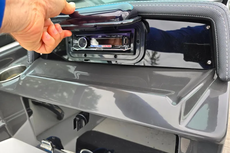 Slide: The Image of Hand opening stereo compartment on 2020 Monterey M-20 boat dashboard. - 14