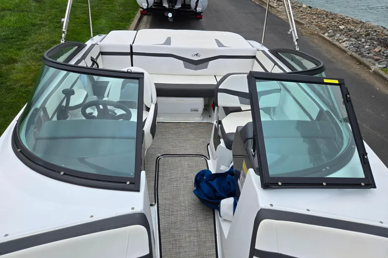 Slide: The Image of 2020 Monterey M-20 boat interior with open windshield, docked near a rocky shoreline. - 20