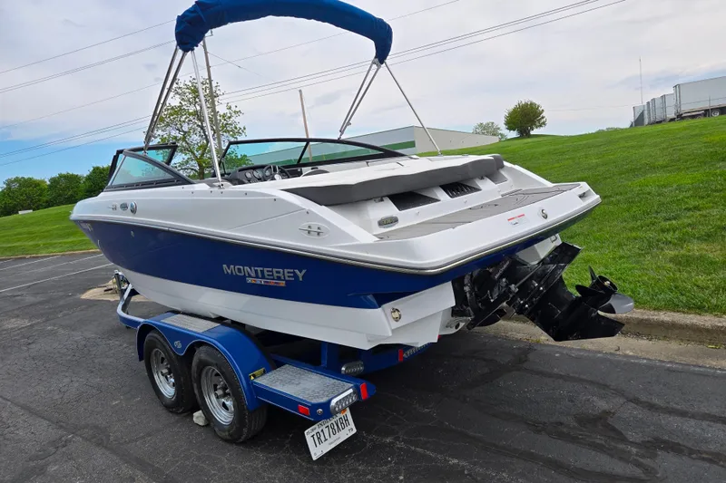 Slide: The Image of 2020 Monterey M-20 boat on trailer, blue and white design, parked on asphalt near grassy area. - 3