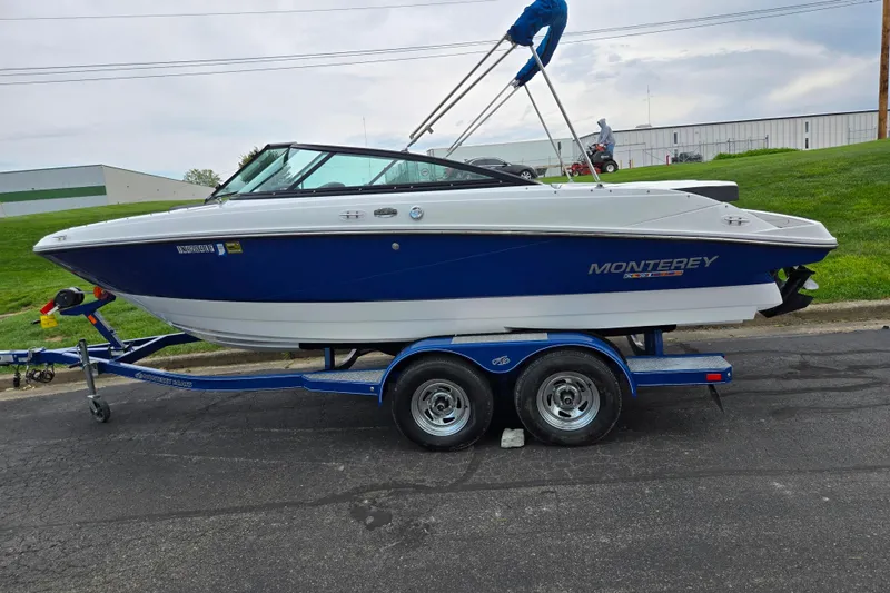 Slide: The Image of 2020 Monterey M-20 boat on trailer, blue and white design, parked outdoors. - 4