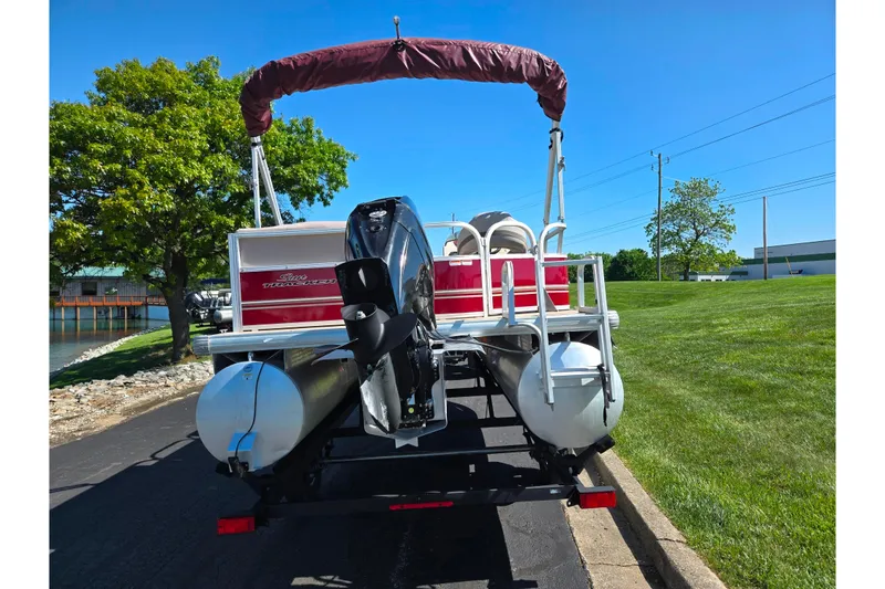 Slide: The Image of 2014 Sun Tracker Party Barge 20 DLX pontoon boat on trailer, parked near a lake. - 2
