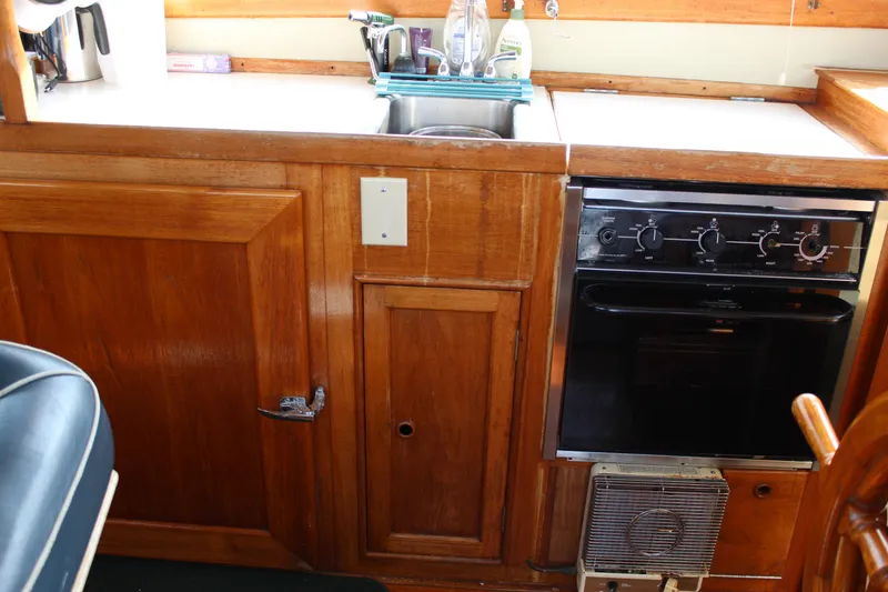 Slide: The Image of 1971 Grand Banks 36 Classic yacht kitchen with wooden cabinetry and stove. - 18