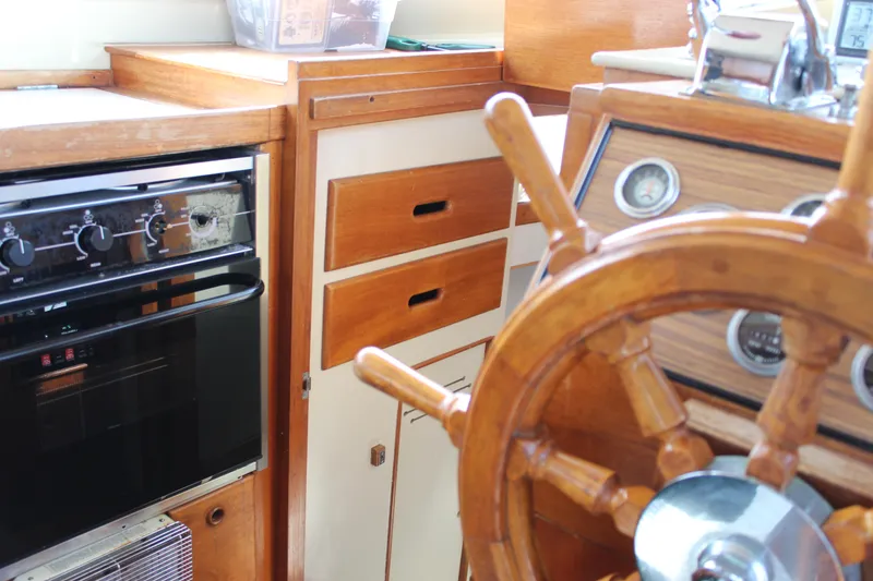 Slide: The Image of Interior of a 1971 Grand Banks 36 Classic boat with wooden helm and kitchen area. - 19