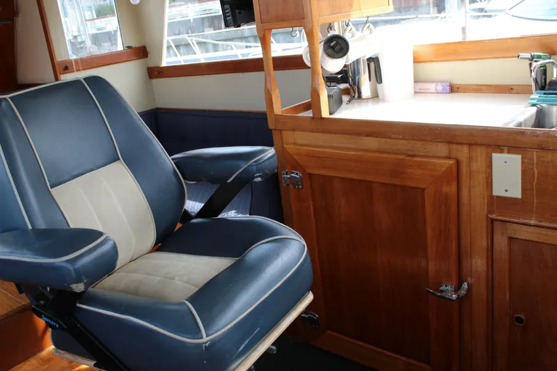 Slide: The Image of Interior of a 1971 Grand Banks 36 Classic boat with blue captain's chair and wooden cabinetry. - 20