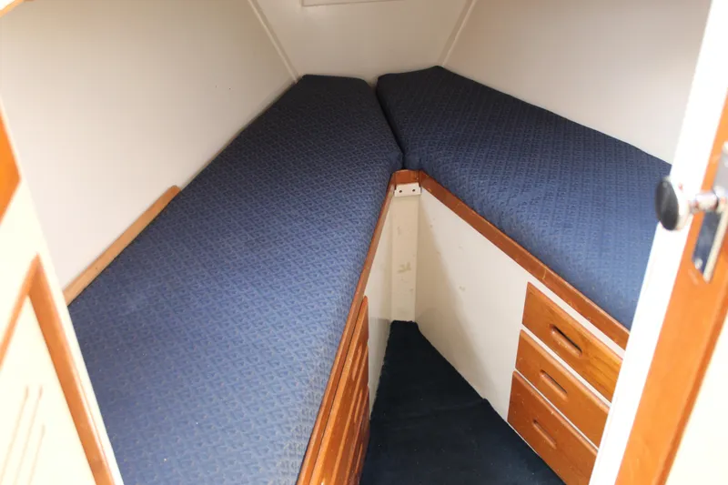 Slide: The Image of Cozy cabin interior of 1971 Grand Banks 36 Classic with blue twin beds and wooden drawers. - 21