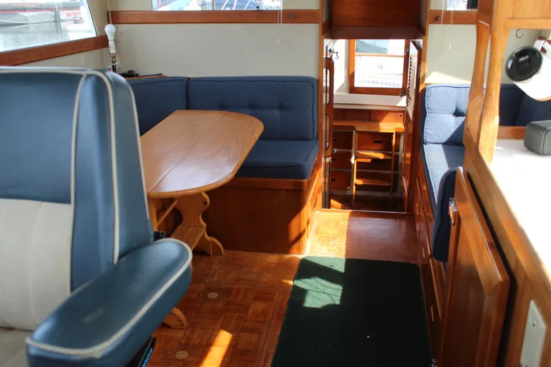 Slide: The Image of Interior of a 1971 Grand Banks 36 Classic yacht with wooden furnishings and blue seating. - 23