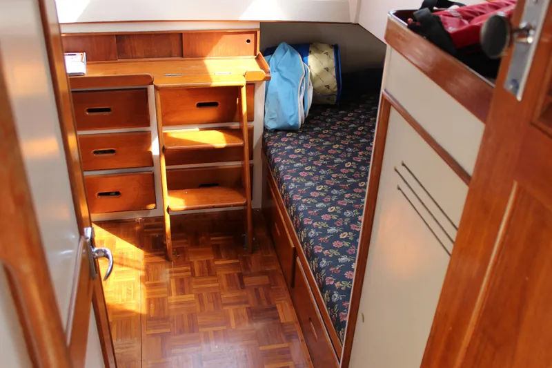 Slide: The Image of Interior of 1971 Grand Banks 36 Classic with wooden desk and floral-patterned bed. - 24