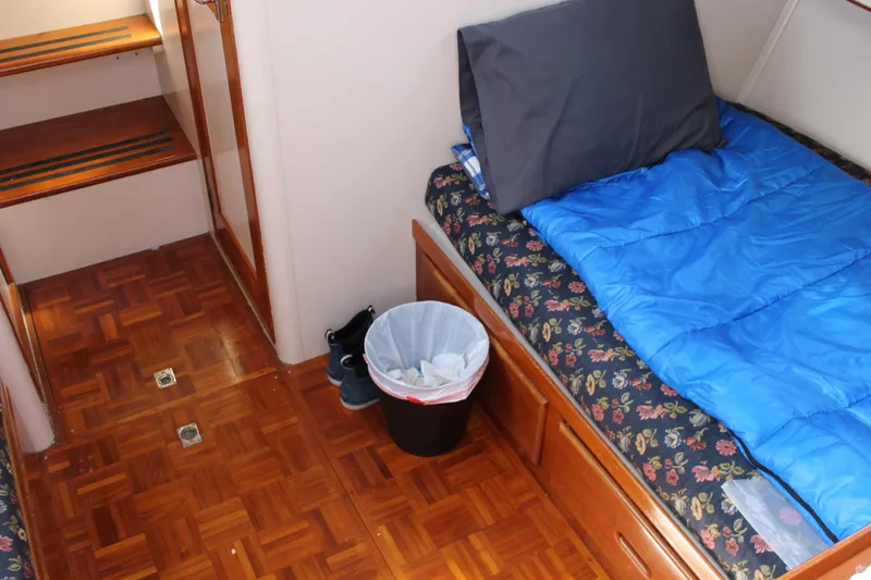 Slide: The Image of Interior of 1971 Grand Banks 36 Classic with bed, blue sleeping bag, and wooden flooring. - 27