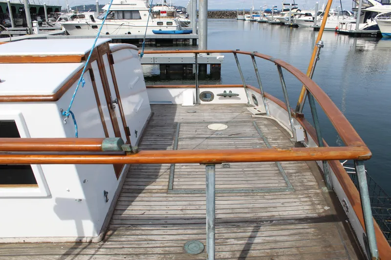 Slide: The Image of 1971 Grand Banks 36 Classic yacht deck with wooden railings in a marina setting. - 8
