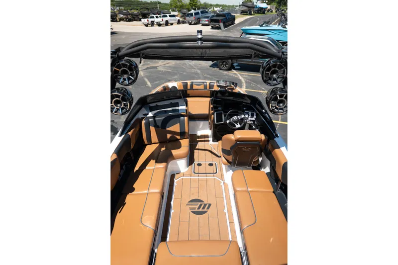 Slide: The Image of 2022 Malibu Wakesetter 23 MXZ boat interior with tan seating and modern dashboard. - 15