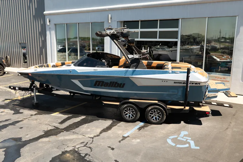 Slide: The Image of 2022 Malibu Wakesetter 23 MXZ boat on trailer, parked outside a showroom. - 3