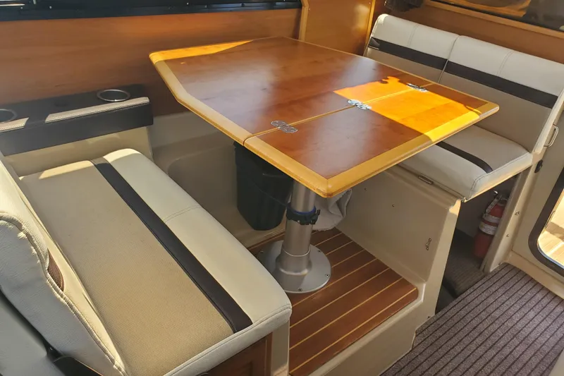Slide: The Image of 2013 Cutwater 26 interior dining area with wooden table and cushioned seating. - 13