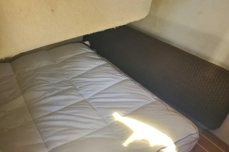 Slide: The Image of Interior cabin bed of a 2013 Cutwater 26 boat, featuring a cozy mattress and cushioned wall. - 17
