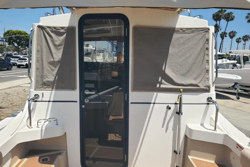 Slide: The Image of 2013 Cutwater 26 boat rear view with covered windows and glass door. - 19
