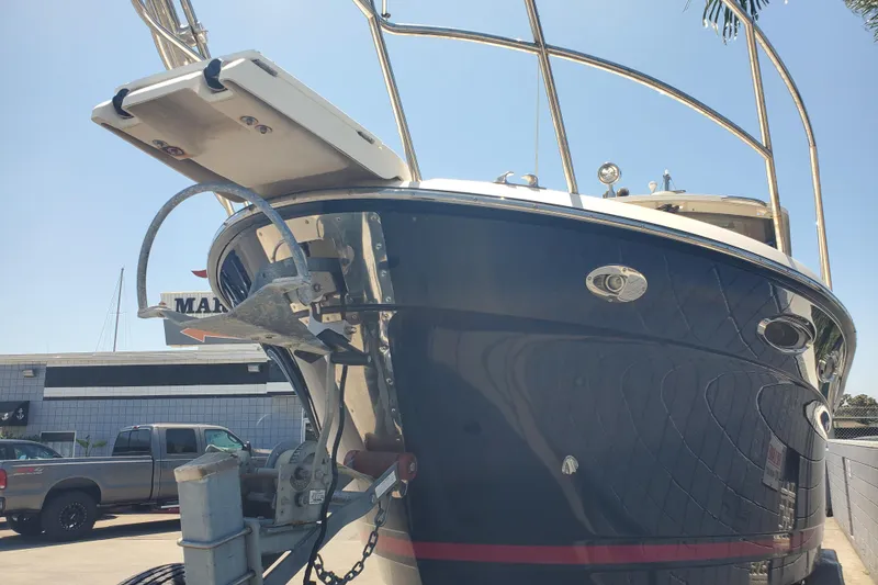 Slide: The Image of 2013 Cutwater 26 boat, docked, with visible anchor and railing, under clear blue sky. - 35