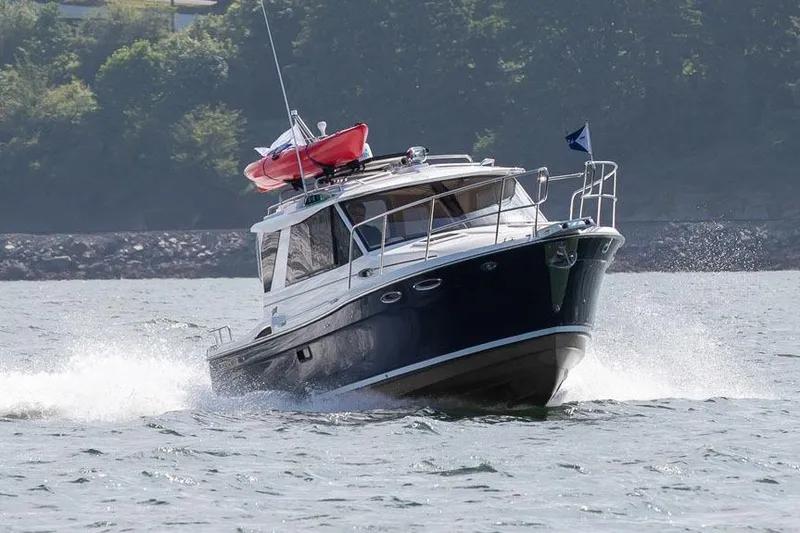 Slide: The Image of Manufacturer Provided Image: 2016 Cutwater 26 boat cruising on water with kayak on roof. - 38