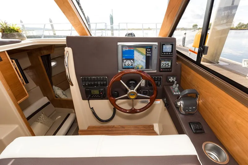 Slide: The Image of Manufacturer Provided Image: 2016 Cutwater 26 boat helm with navigation equipment and wooden steering wheel. - 42
