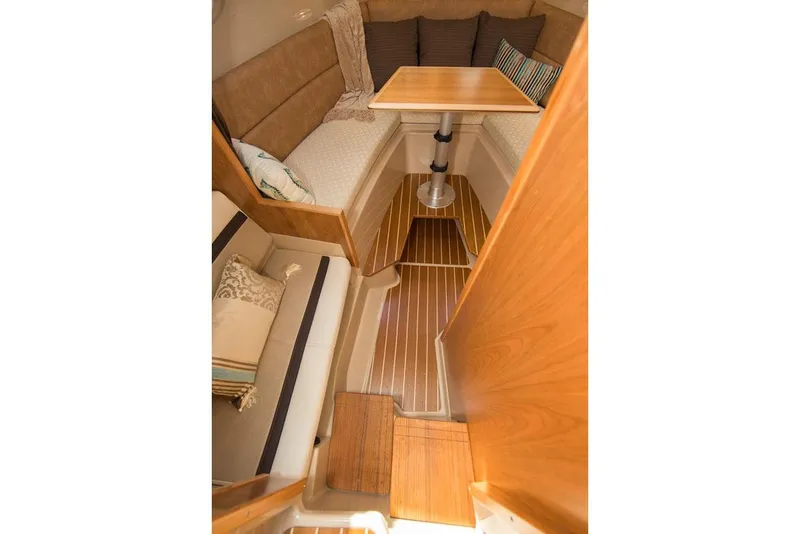 Slide: The Image of Manufacturer Provided Image: 2016 Cutwater 26 interior with cozy seating and wooden table. - 44