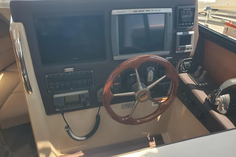 Slide: The Image of 2013 Cutwater 26 boat helm with steering wheel, navigation screens, and control panel. - 5