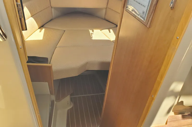Slide: The Image of Interior cabin of a 2013 Cutwater 26 boat with beige cushions and wooden flooring. - 6