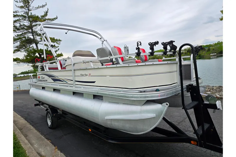 Slide: The Image of 2008 Sun Tracker Fishin' Barge 21 Signature Series pontoon boat on trailer by a lake. - 8