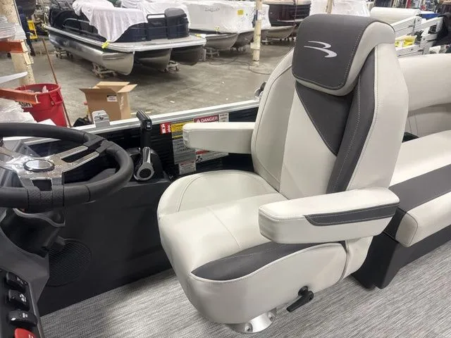 Slide: The Image of Interior of a 2026 Bennington pontoon boat with steering wheel and seat. - 17