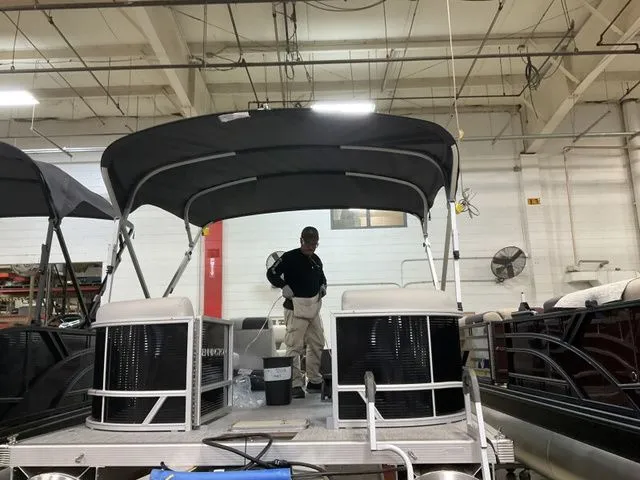 Slide: The Image of Bennington 2026 pontoon boat in workshop with black canopy. - 9