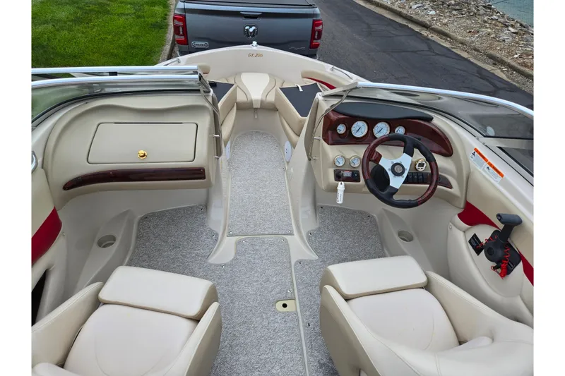 Slide: The Image of 2005 Glastron GX 205 boat interior with beige seating and dashboard controls. - 11