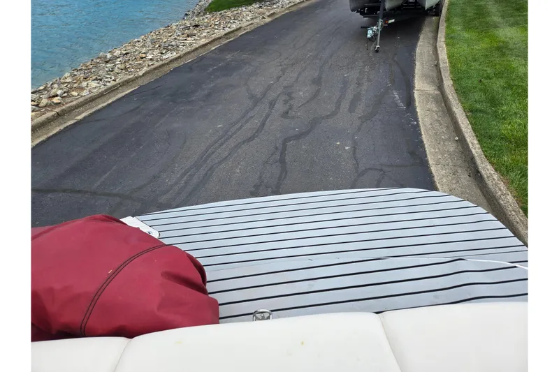 Slide: The Image of 2005 Glastron GX 205 boat on trailer near water and grassy area. - 24