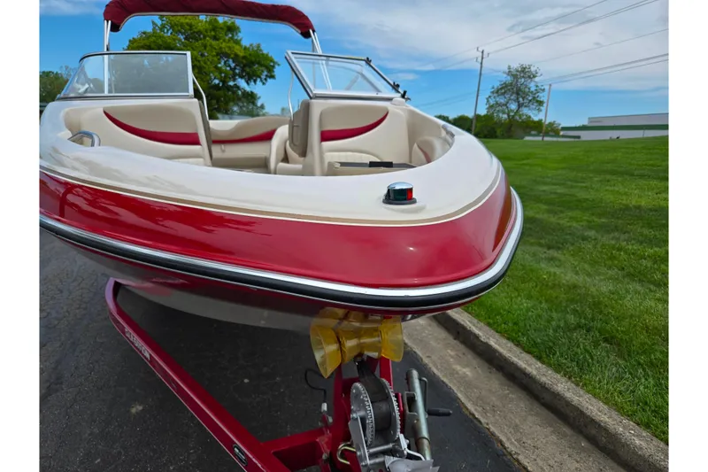 Slide: The Image of 2005 Glastron GX 205 boat with red and white exterior, parked on a trailer. - 6