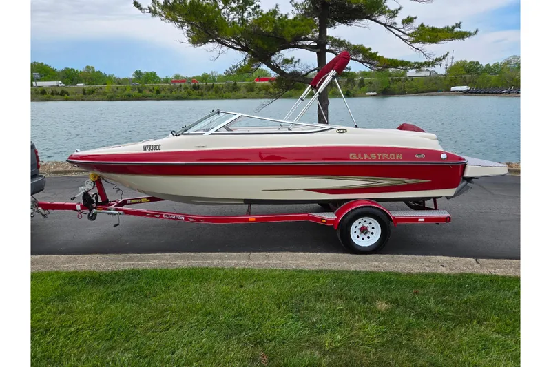 Slide: The Image of 2005 Glastron GX 205 boat on trailer by a lakeside road. - 9